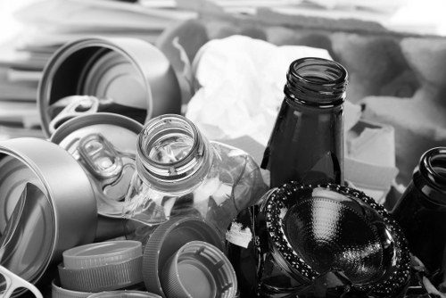 Sudbury Skip Hire branded skip beside a driveway with staff preparing equipment